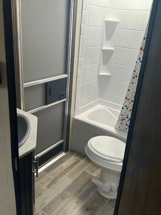RV rental bathroom: compact design with toilet, tub/shower, and sink vanity. Perfect for travel comfort.. Forest River Cherokee Grey Wolf 2020