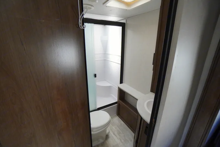 Modern and clean RV rental bathroom, featuring a compact shower, toilet, and vanity.. Forest River Tracer 2021