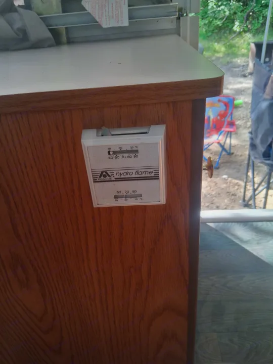 This RV rental features an Atwood Hydro Flame thermostat on a wood cabinet for climate control, viewing outside.. Bonair 1050C 1996