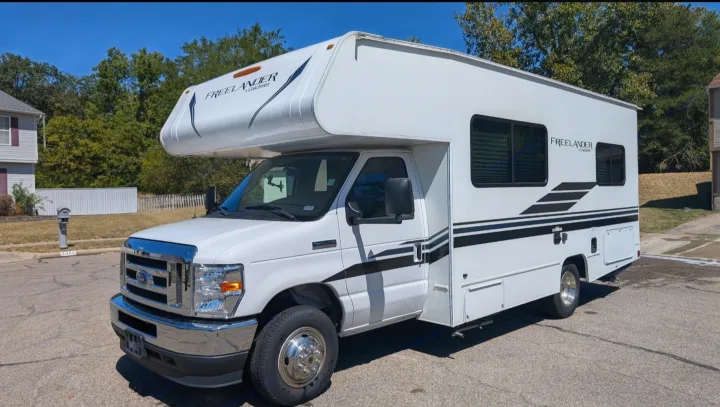 Bright white Coachmen Freelander rv rental parked on a sunny residential street.. Forest River Coachmen Freelander 2021