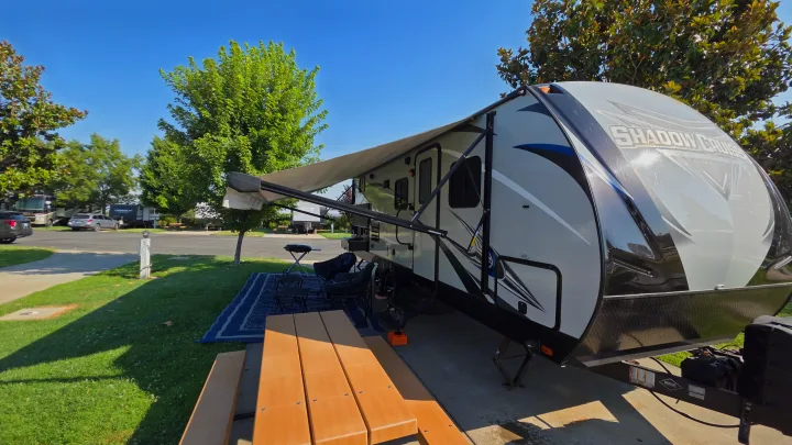 RV rental: A Shadow Cruiser travel trailer with an extended awning, picnic table, and outdoor seating at a sunny campsite.. Shadow Cruiser 240RBH 2019
