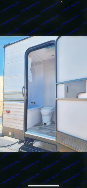 Inside an RV rental: a compact bathroom with a toilet and shower unit, offering essential amenities for travelers.. Dutchmen Coleman Lantern 2022
