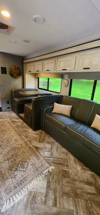 View inside a spacious rv rental. Features a modern dinette, comfy sofa, light cabinets, and wood-look flooring.. Forest River Sunseeker LE 2022