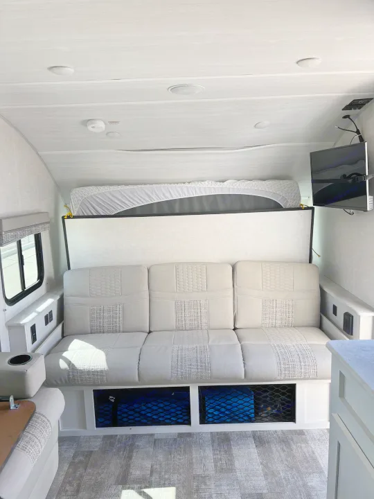 This RV rental features a comfy sofa with under-seat storage, a fold-down bed, and a TV, providing a relaxing and practical space.. Forest River R-Pod 2021