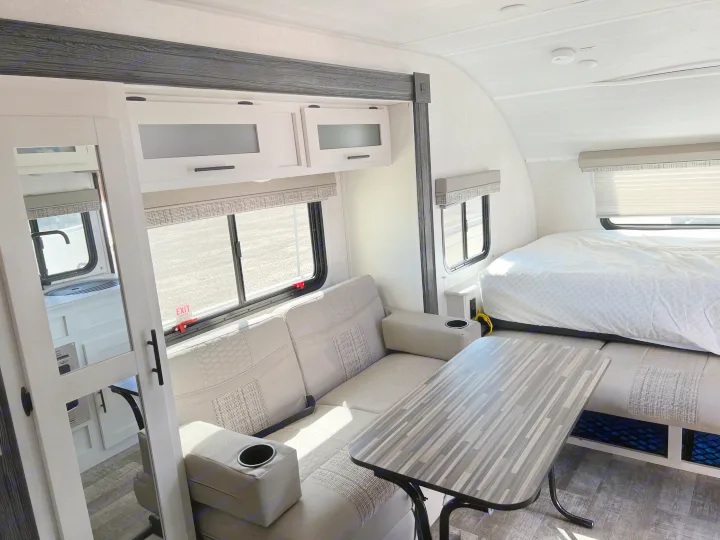 Modern RV rental interior: sofa, dining table, and bed area, offering comfortable travel living.. Forest River R-Pod 2021
