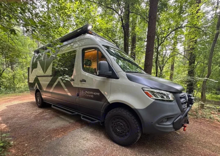 Adventure-ready Nowhere Vans RV rental in the forest. This custom light grey camper van is perfect for van life camping.. Mercedes-Benz Sprinter RV Motorhome Campervan 2022