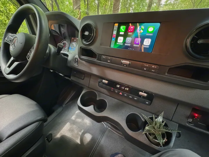 Mercedes-Benz RV rental interior: Modern dashboard with Apple CarPlay screen, climate controls, and cup holders.. Mercedes-Benz Sprinter RV Motorhome Campervan 2022