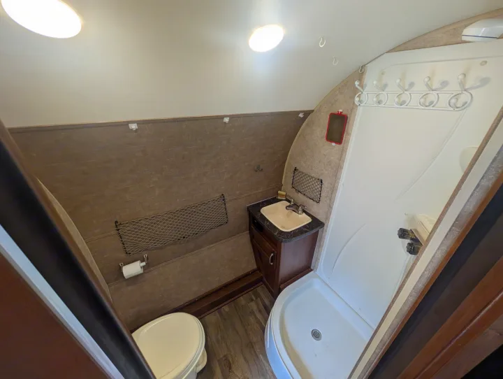 Compact RV rental bathroom featuring a shower, toilet, and sink, designed for comfort on the road.. Jayco Hummingbird 2017