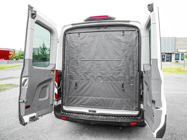 Customized RV rental cargo van with open rear doors, showing an interior dark grey fabric partition for privacy or storage.. Ford Transit 2019
