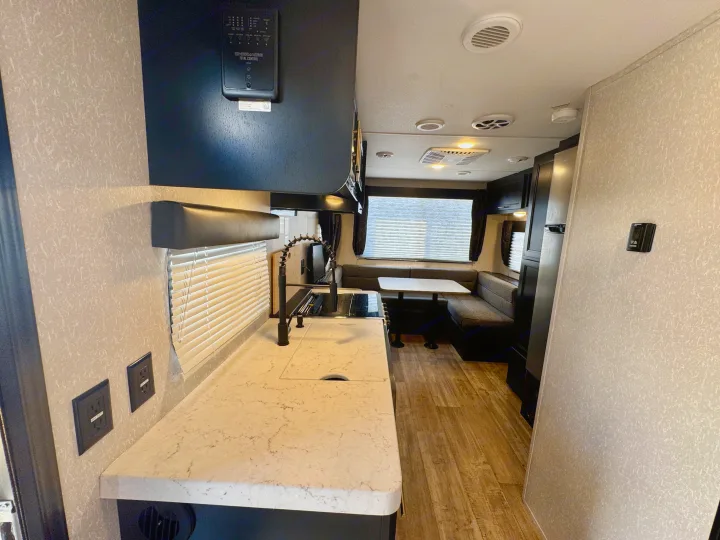 Modern RV rental interior with a fully equipped kitchen, spacious dinette, and comfortable living area. Ideal for travel.. Forest River Grey Wolf Limited 2022