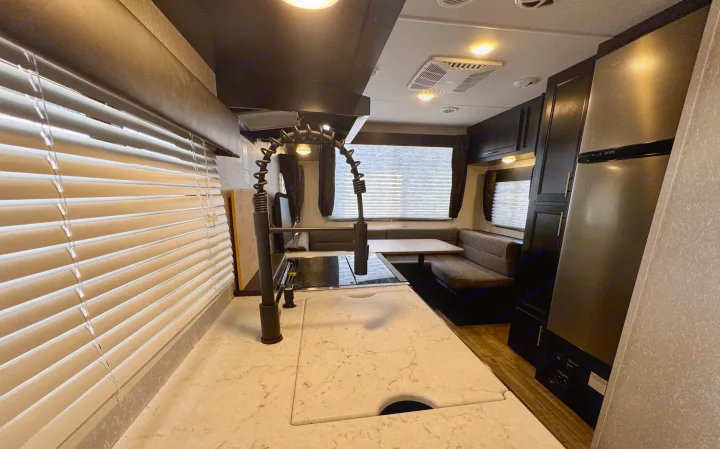 Spacious RV rental interior featuring a modern kitchen with a large faucet, dinette seating, and stainless steel refrigerator.. Forest River Grey Wolf Limited 2022
