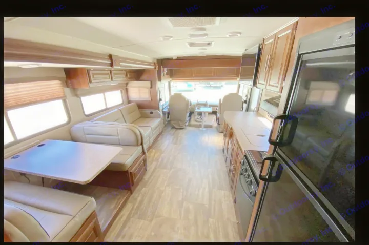 Step inside this modern RV rental! View of the kitchen, dinette, and living area, leading to the front cockpit.. Forest River Georgetown 2018