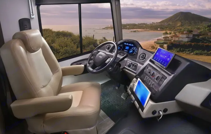 Modern RV rental cockpit with comfortable driver's seat, advanced dashboard, and a stunning panoramic coastal ocean view for travel.. Forest River gt5 2022