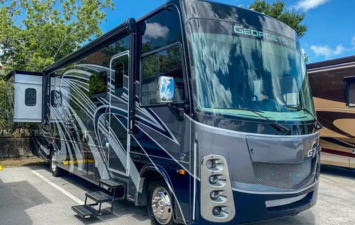This sleek Georgetown RV rental is ready for adventure! Dark blue with bold graphics, featuring an extended slide-out.. Forest River gt5 2022