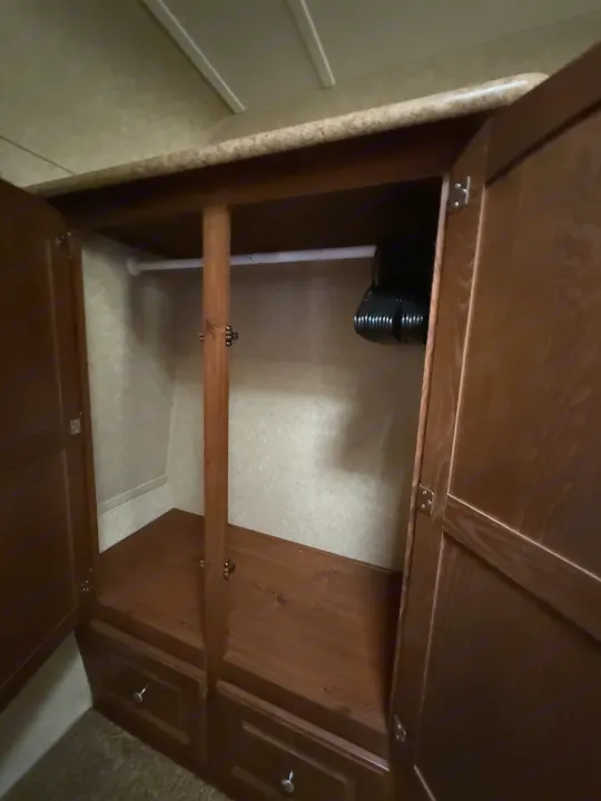 RV rental wardrobe: open closet showing hanging rod, shelf, drawers, and hangers for ample storage.. Rockwood Signature Ultra Lite 2012