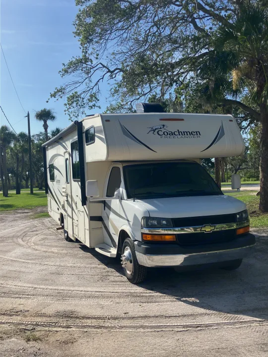 White Coachmen Freelander RV rental parked on a sunny day. Perfect for camping and exploring the outdoors.. Forest River Coachmen Freelander 2017