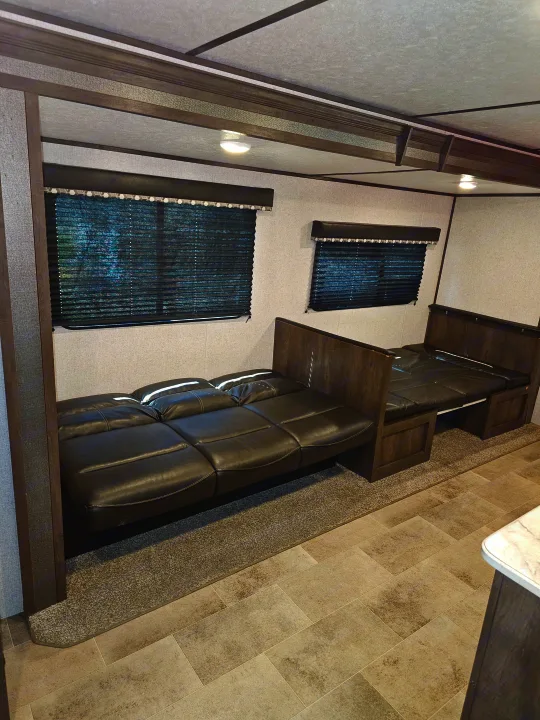 Spacious RV rental interior with convertible sofas/beds, blinds, and modern finishes, perfect for travel comfort.. Dutchmen Coleman Lantern 2021