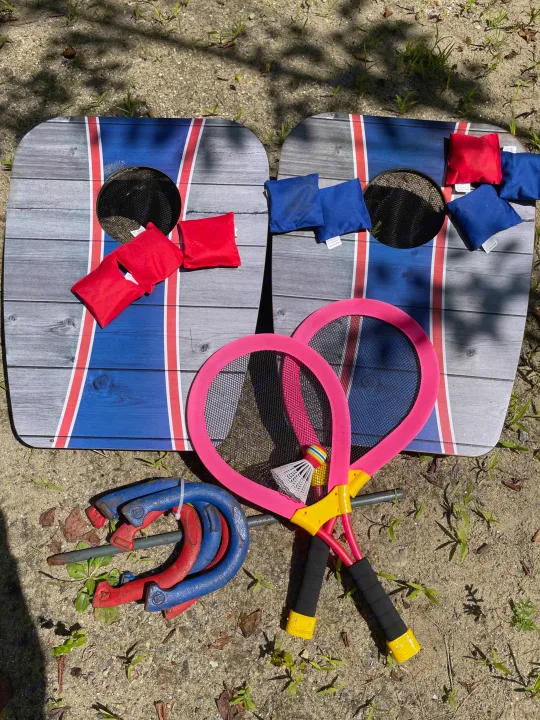 RV rental ready! Outdoor games: cornhole boards with red/blue bags, pink badminton rackets, and horseshoe set on sandy earth.. Jayco Jay Flight SLX 2021