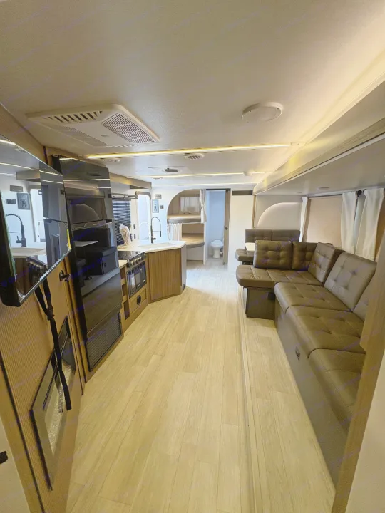 Spacious RV rental interior featuring a modern kitchen, L-shaped sofa living area, bunk beds, and bathroom for comfortable travel.. Forest River Salem Cruise Lite 26ICE 2025