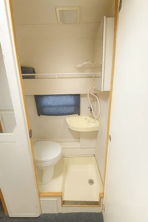 RV rental: Compact onboard bathroom with toilet, small sink/shower combo, and ceiling light. Efficient use of space.. Pleasure Way Excel 2001
