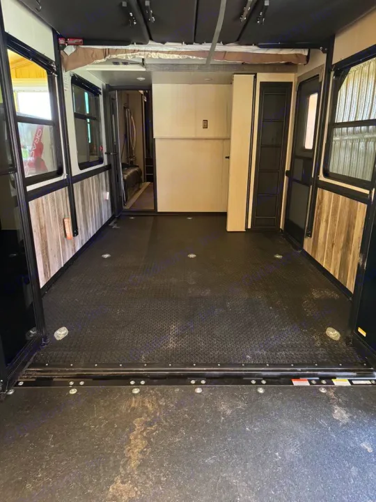 Inside this RV rental, see a toy hauler's spacious, durable garage with black diamond plate flooring & fold-down bed. Perfect for cargo.. Heartland Cyclone 2022
