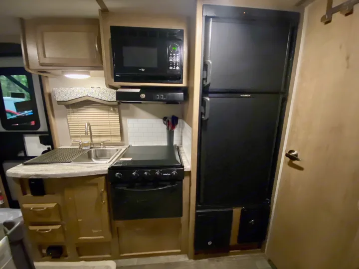 RV rental kitchen interior: features a sink, microwave, stove, and refrigerator for comfortable travel.. Winnebago Minnie Winnie 2020