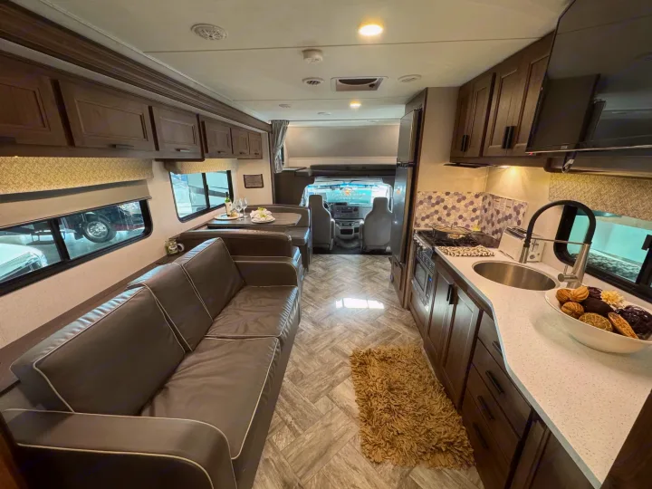 Spacious RV rental interior with living, dining, and kitchen areas. Features sofa, dinette, and full kitchen.. Forester LE 2022