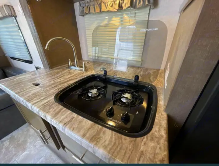 Compact RV kitchen with a sink, faucet, and two-burner stove. Ideal for your next RV rental adventure!. R-Pod R-Pod Trailer 2018