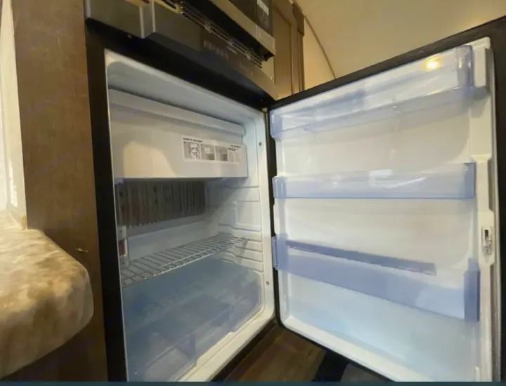 Clean, empty RV rental refrigerator, ready for your travel essentials. Features a small freezer and door storage.. R-Pod R-Pod Trailer 2018