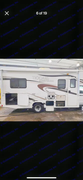White Tioga Montara RV rental side view. Open storage compartments reveal equipment for travel.. Tioga Montara 2012