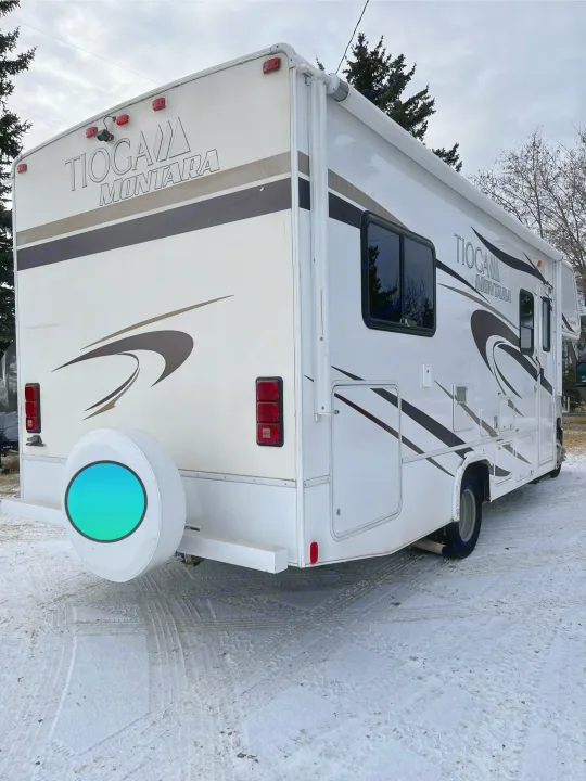 This Tioga Montara RV rental, with its white body and brown accents, is parked in a snowy setting.. Tioga Montara 2012