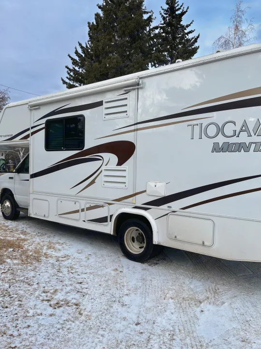 White Fleetwood Tioga RV rental parked on snowy ground.. Tioga Montara 2012