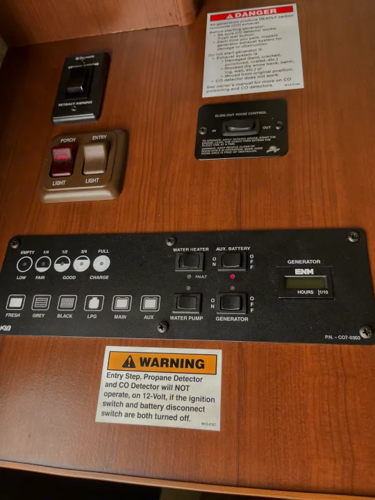 An RV rental control panel displaying awning, slide, lights, generator, water, and tank level readouts for user operation.. Tioga Montara 2012