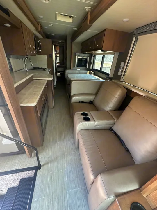 Spacious rv rental interior with a fully equipped kitchen, comfortable dining area, and plush recliners.. Thor Challenger 2022