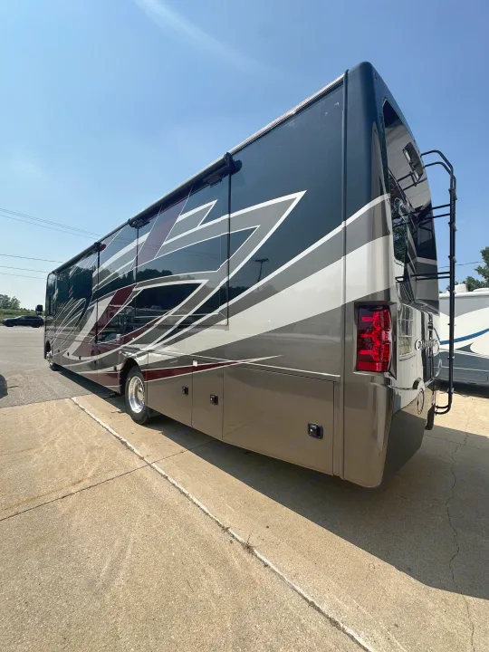 A modern dark grey and maroon RV rental, with bold graphics, is parked on concrete, ready for your road trip adventure.. Thor Challenger 2022