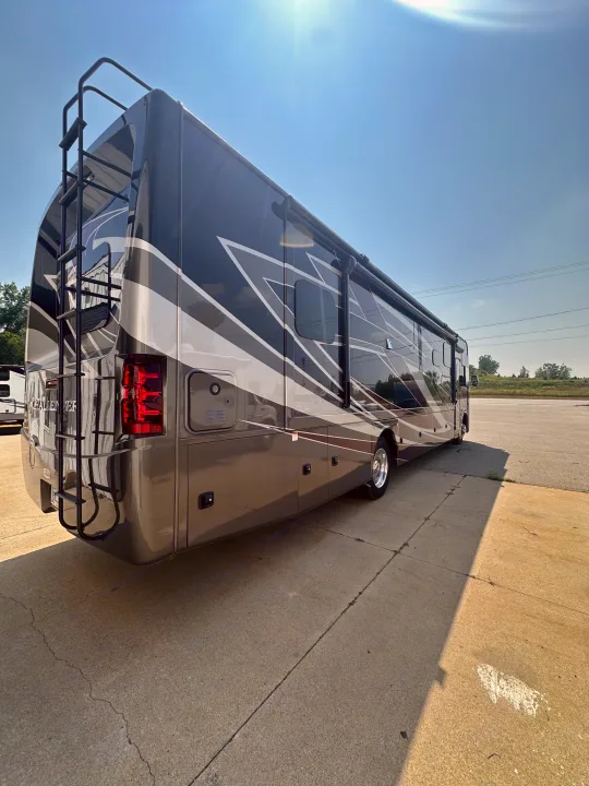 A modern, sleek gray RV motorhome with distinctive graphics, perfect for your next RV rental, parked under a sunny sky.. Thor Challenger 2022