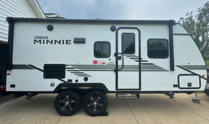This white Winnebago Micro Minnie travel trailer, model 2108TB, is ready for an RV rental adventure, parked on a driveway.. Minnie Micro Minnie 2021