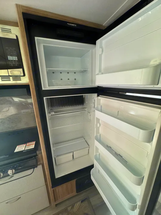 Empty Dometic fridge and freezer open in an RV rental. Ready for groceries on your next road trip.. Minnie Micro Minnie 2021