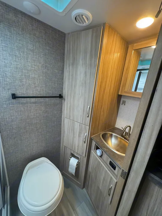 Bathroom features sink, toilet, shower, and ample storage for longer trips. A pocket door saves space.. Minnie Micro Minnie 2021