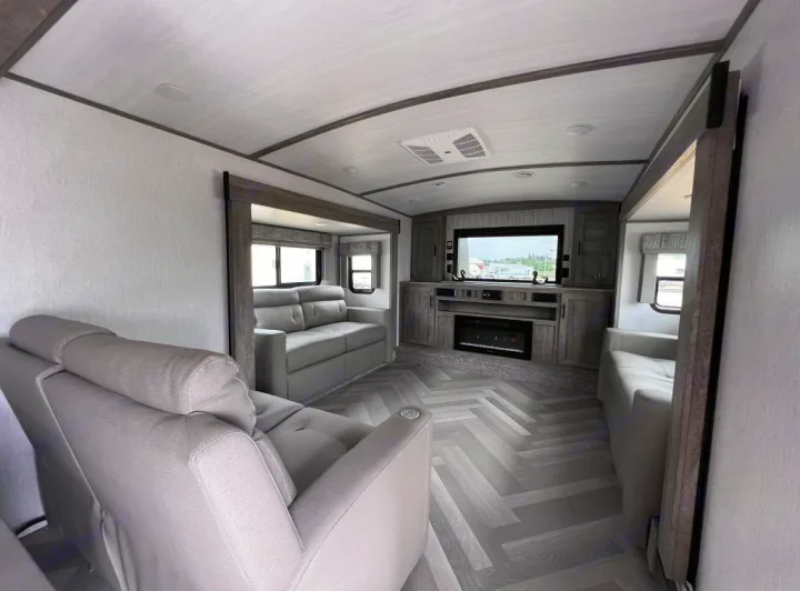 Spacious RV rental interior featuring comfortable sofas, a large TV, and an electric fireplace.. Forest River Salem Hemisphere 2022