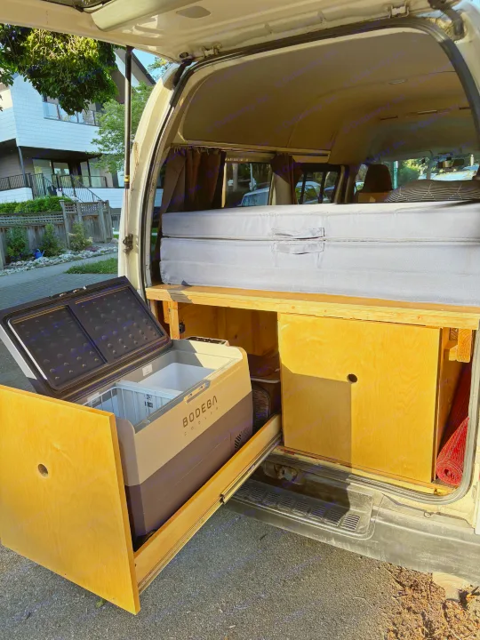 RV rental camper van interior: pull-out Bodega cooler, storage, and folded bed setup, ready for mobile adventures.. Toyota Hiace 2006