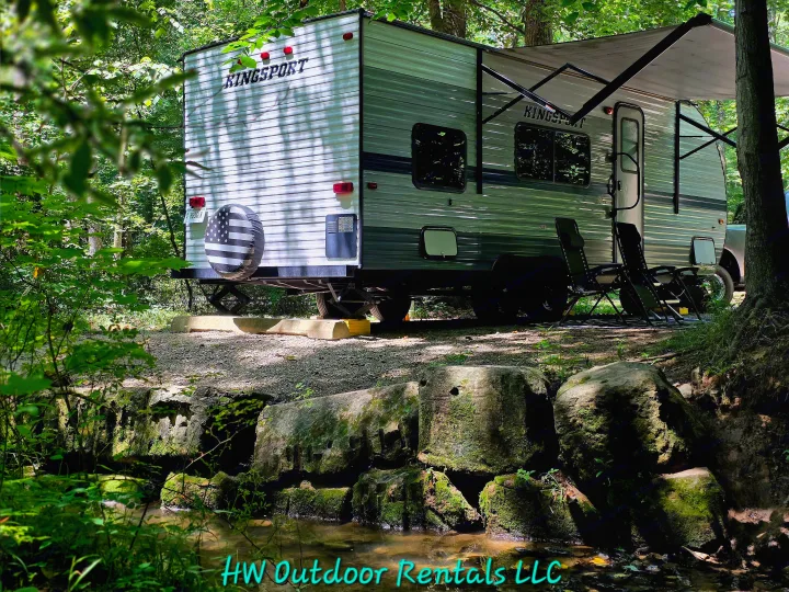 Kingsport RV rental by a peaceful stream at a shaded campsite. Experience nature's beauty and comfort.. Gulf Stream Kingsport 2020