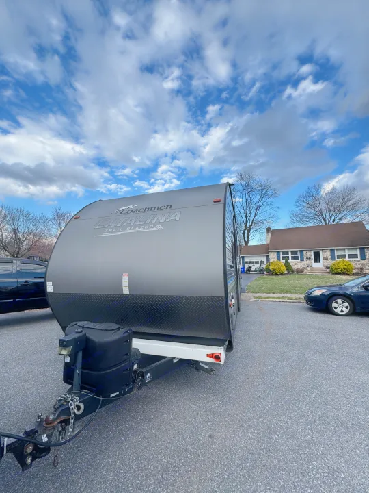 Gray Coachmen Catalina Trail Blazer travel trailer, perfect for an RV rental adventure, parked on an asphalt street.. Coachmen Catalina 2021