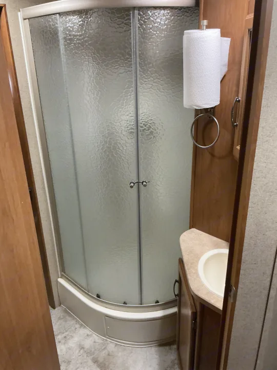 RV rental: Enjoy a practical bathroom with a textured glass shower, sink vanity, and paper towel dispenser for your travels.. Crossroads RV Sunset Trail Super Lite 2017