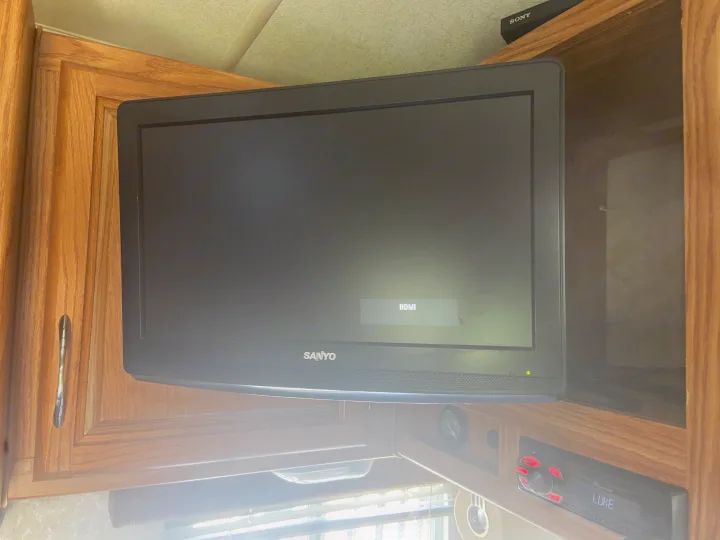 RV rental entertainment setup: Sanyo TV (HDMI) in wood cabinet, with Sony device above & Pioneer stereo below showing 'LUKE'.. Eclipse Recreational Vehicles Attitude 2006