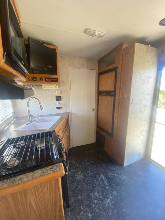 Experience home comfort in this RV rental kitchen, equipped with a gas stove, sink, microwave, and fridge for your adventures.. Eclipse Recreational Vehicles Attitude 2006