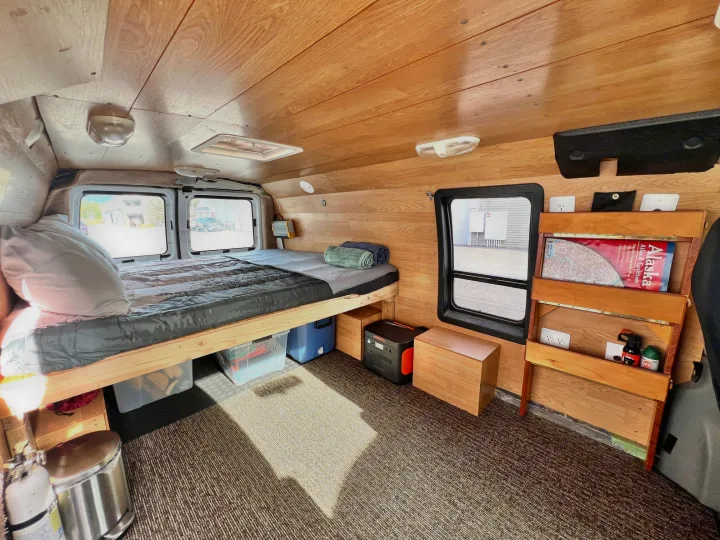 Experience van life in this RV rental: a wood-paneled camper with a bed, windows, and storage for travel.. Ford Econolline 250s 2006