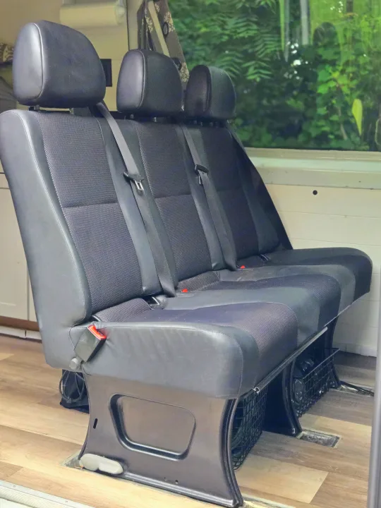 RV rental: Three dark passenger seats with seatbelts secured to a laminate floor in a camper van interior.. Freightliner Sprinter 2011