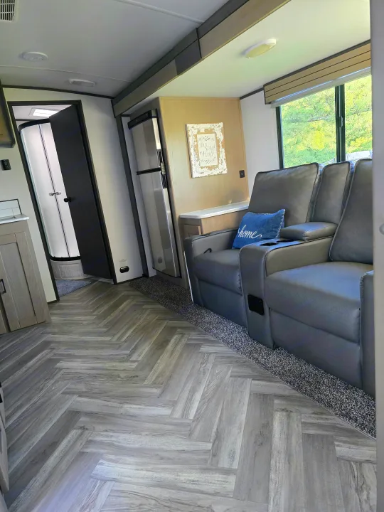 Step inside this RV rental! Features include comfy grey recliners, a kitchenette with fridge, bathroom access, and stylish wood-look flooring.. Cruiser RV Shadow Cruiser 2021