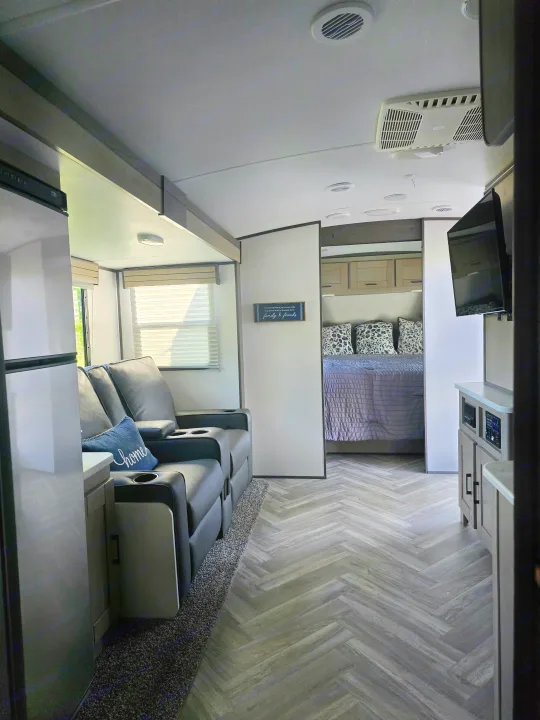 Step into a modern RV rental! Spacious interior features a comfy living area with recliners, kitchenette, and a private bedroom. Perfect for travel.. Cruiser RV Shadow Cruiser 2021